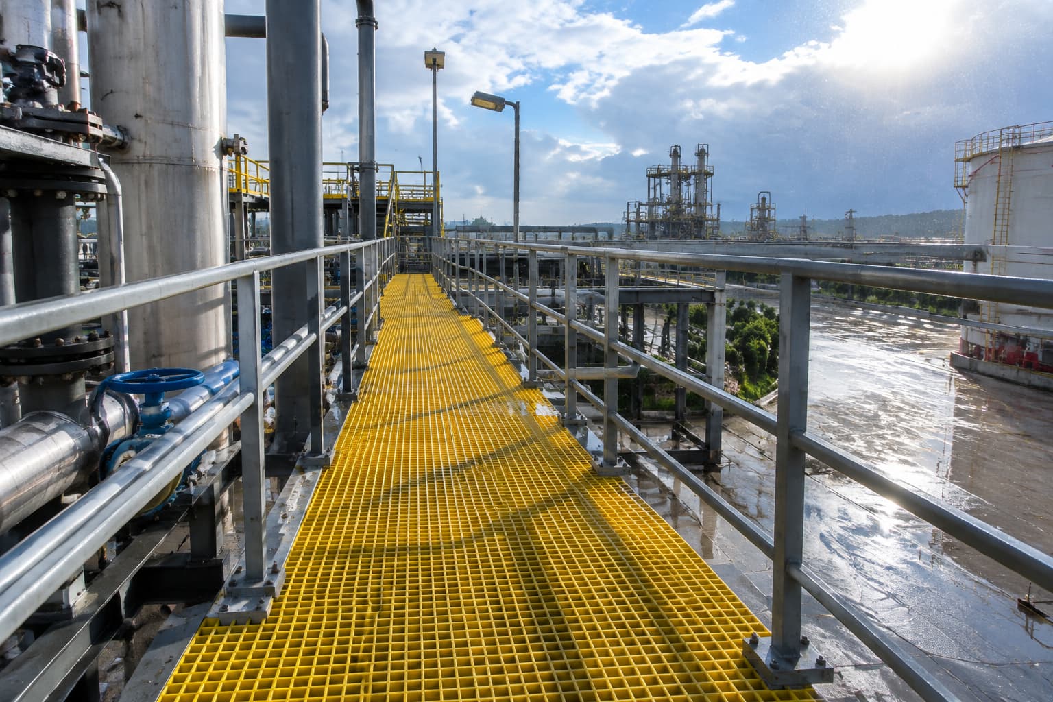 Outdoor FRP grating walkway exposed to sunlight rain and changing weather conditions at an industrial facility Outdoor FRP grating walkway exposed to sunlight rain and changing weather conditions at an industrial facility